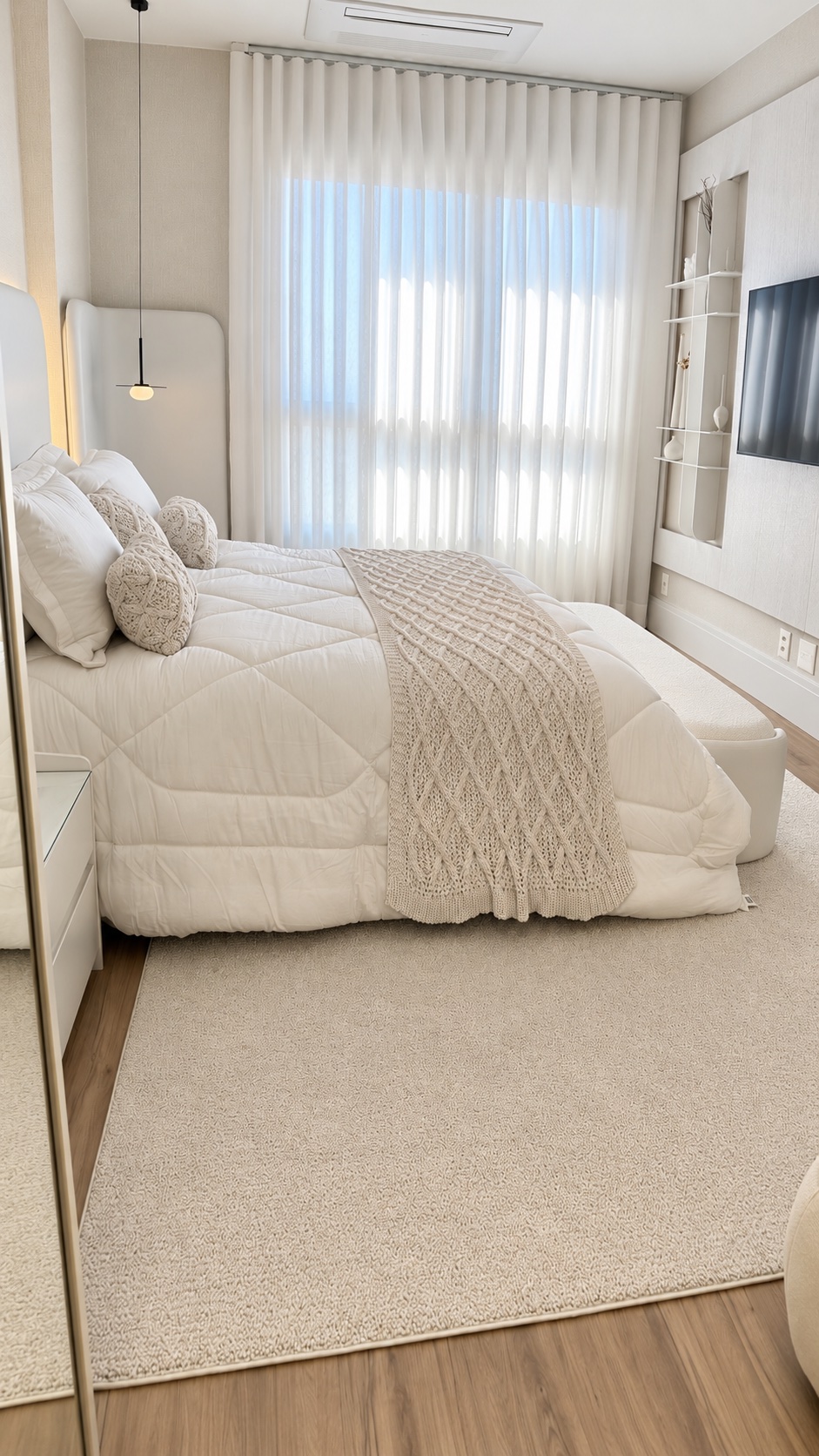 Quarto com cortinas leves, cama e tapete em tons claros