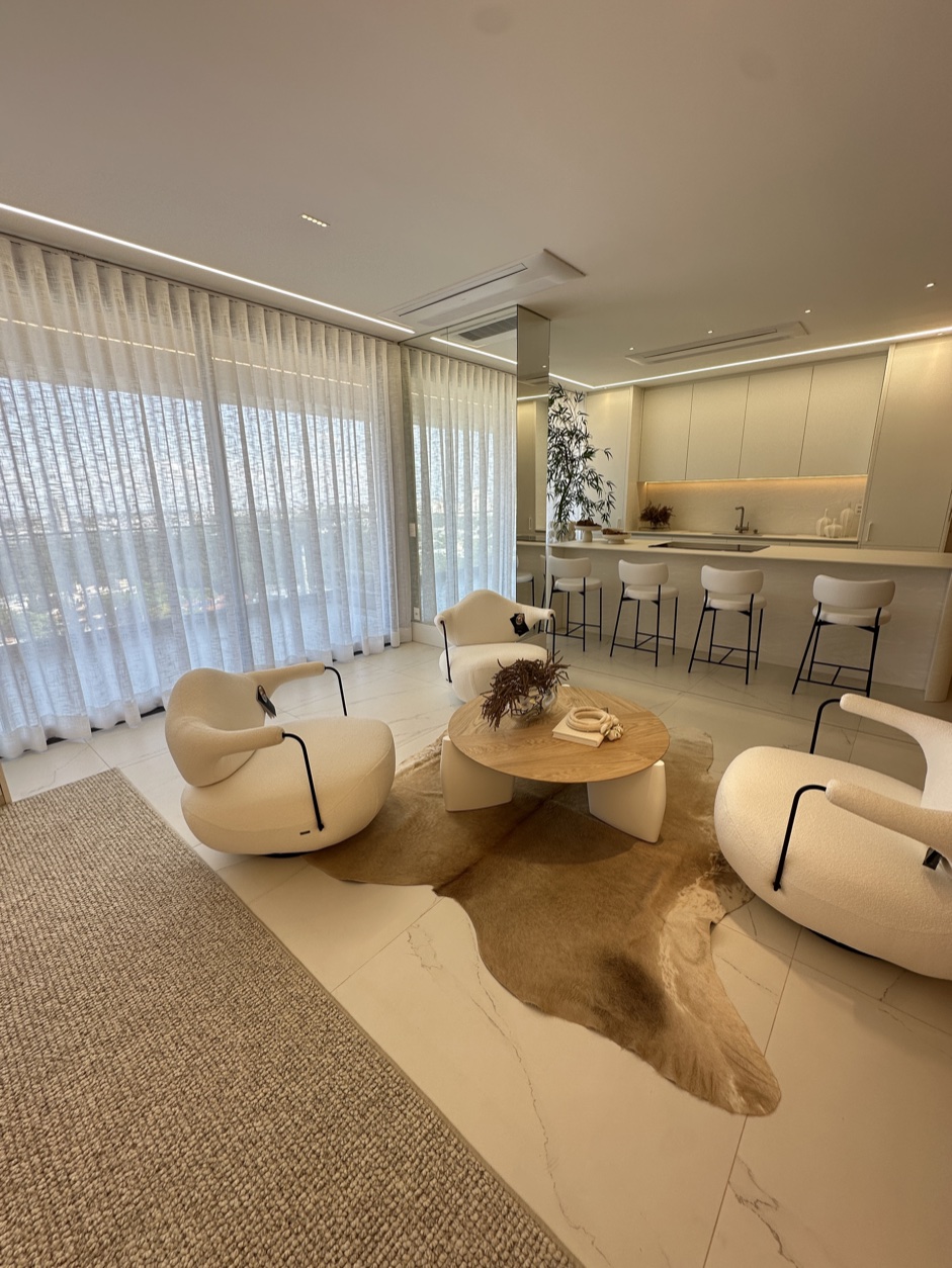Sala de estar com tapete de fibra natural, couro e poltronas