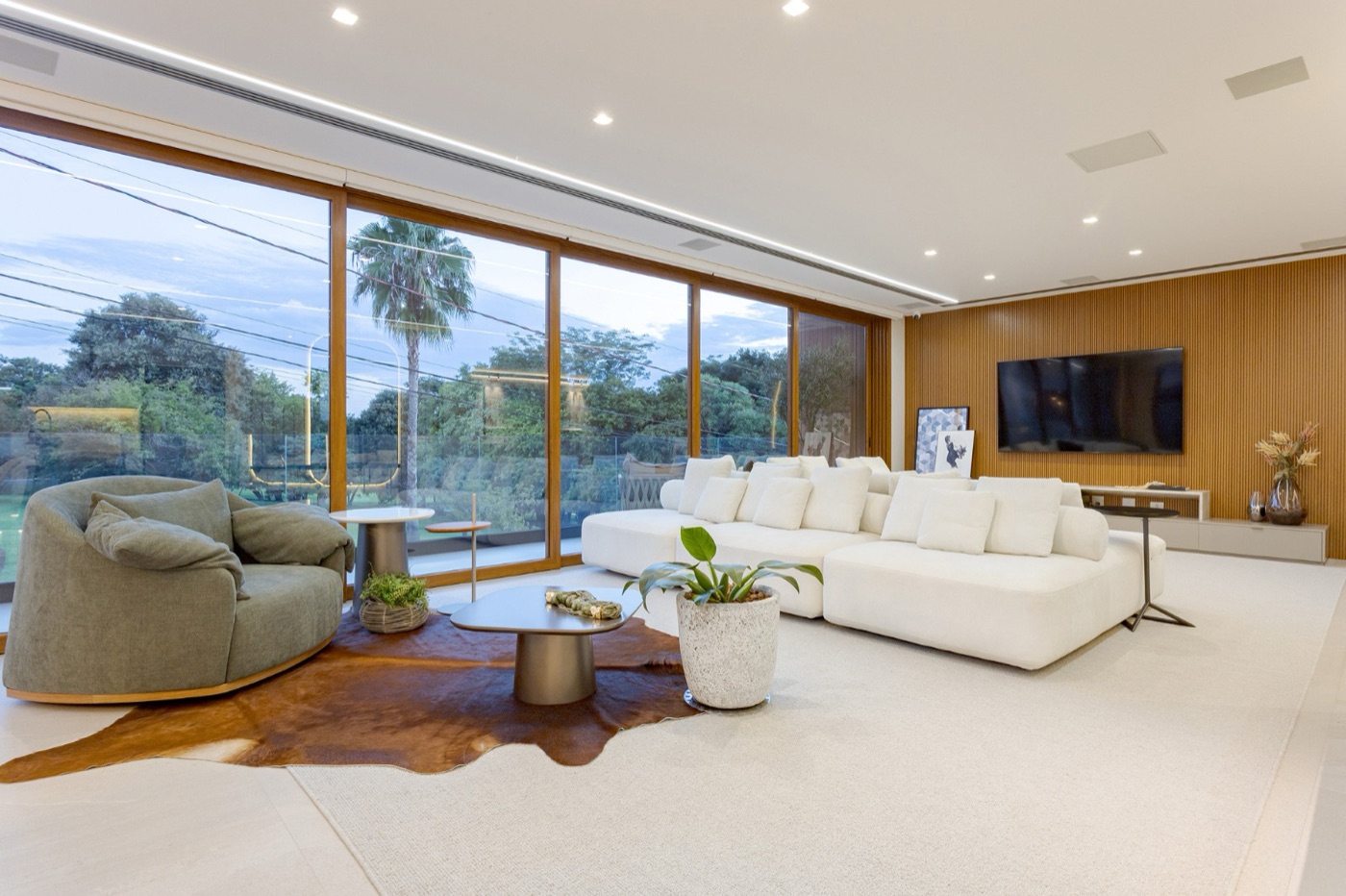 Sala de estar ampla com tapete claro, couro e sofá modular